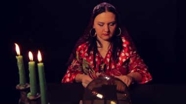 Çingene falcı mum ışığında masada fortunetelling kartları yayılır