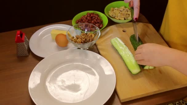Ženské ruce čerstvou okurku nakrájejte na dřevěném prkénku — Stock video