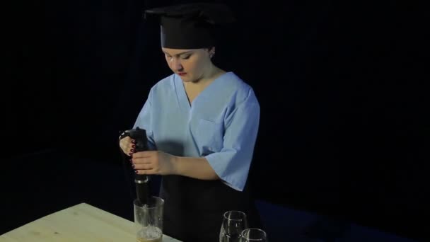 Жінка готує на чорному тлі б'є банан у блендері — стокове відео