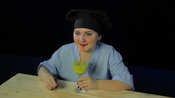 Жінка готує на чорному тлі смакує фруктовий смузі і показує знак Гаразд — стокове відео