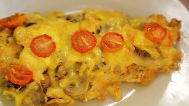 Baked fish in cheese with mushrooms and cherry tomatoes on a white plate — Stock Video