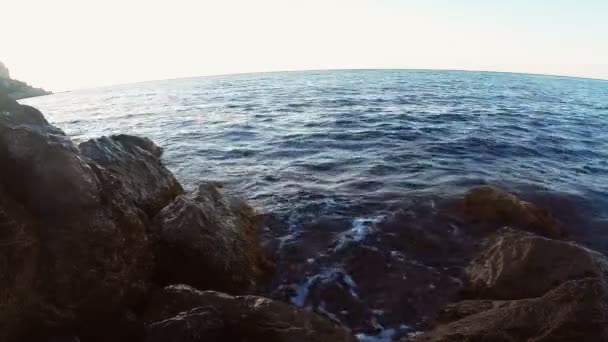 La costa rocosa y las olas que se estrellan en las rocas con vistas al mar abierto — Vídeo de stock