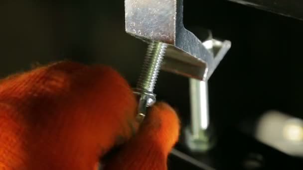 El encendedor en guantes de trabajo desenrosca el tornillo de abrazadera — Vídeos de Stock