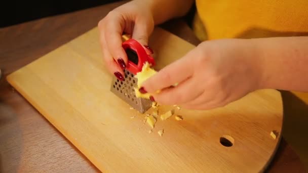 Una mujer está frotando queso para ensalada. Vueltas de tiempo — Vídeo de stock