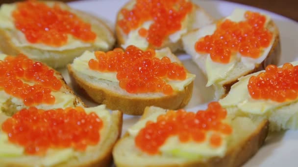 Canapés con caviar rojo en un plato blanco — Vídeos de Stock