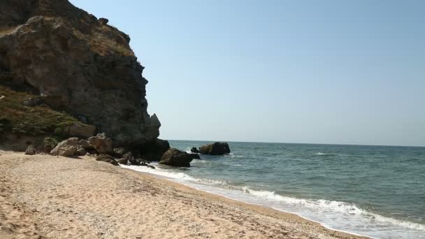 Sand strand och vågor kraschar mot klipporna — Stockvideo