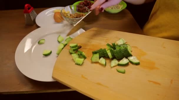 Uma mulher com uma faca transforma pepino em uma placa branca . — Vídeo de Stock