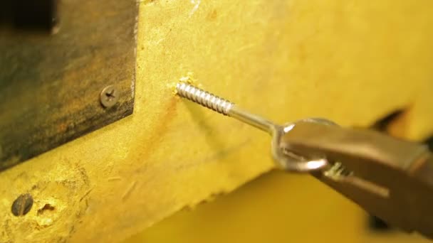 Un hombre está atornillando un anillo de fijación en la pared. Vueltas de tiempo . — Vídeos de Stock