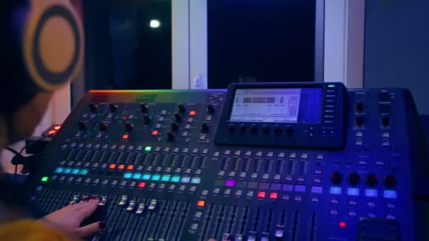 Mãos de uma DJ feminina no console de mixagem misturando faixas para a discoteca — Vídeo de Stock