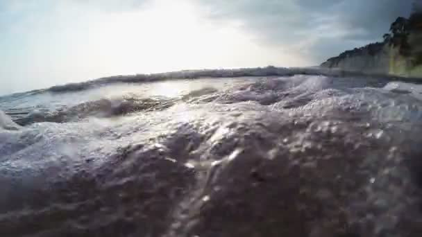 Bord de mer pierreux au coucher du soleil avec des reflets du soleil sur les rochers 