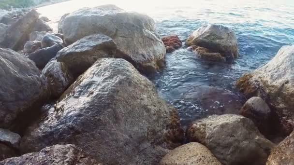 Steniga stranden och havet vatten stänk mellan stenarna — Stockvideo