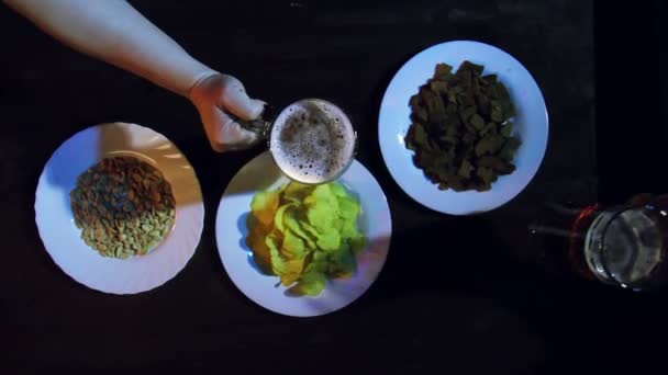 De handen van vrienden aan de bar aan de snack tafel sloeg de volledige bierpullen samen — Stockvideo