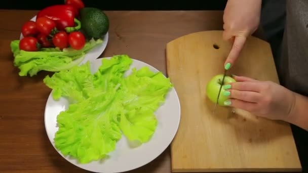 Een Vrouw Snijdt Een Groene Appel Met Een Mes Een — Stockvideo