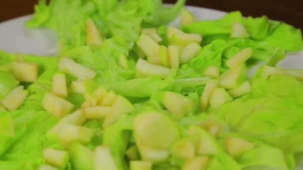 Mano Femenina Pone Rebanadas Manzana Plato Con Hojas Lechuga Primer — Vídeo de stock