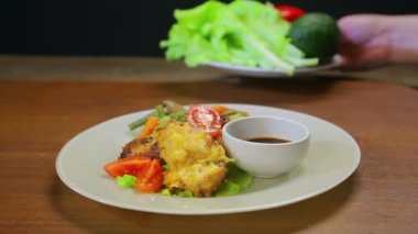 Bir kadın bir Türkiye yemek sebze, kırmızı domates ve soya sosu bir sos kase dilimleri ile süsle. Yakın çekim