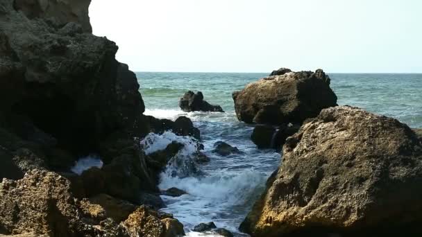 Rocas sobre las que rompen olas espumosas del mar . — Vídeos de Stock