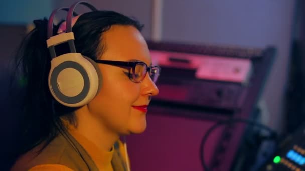 The face of a female DJ in the schoolers and glasses during work — Stock Video