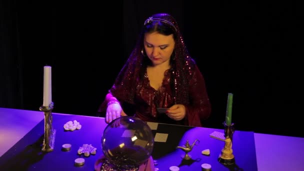 Im magischen Salon bei Kerzenschein wundert sich eine Zigeunerin auf den Karten. — Stockvideo