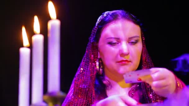 The face of a young gypsy fortune-teller with cards — Stock Video