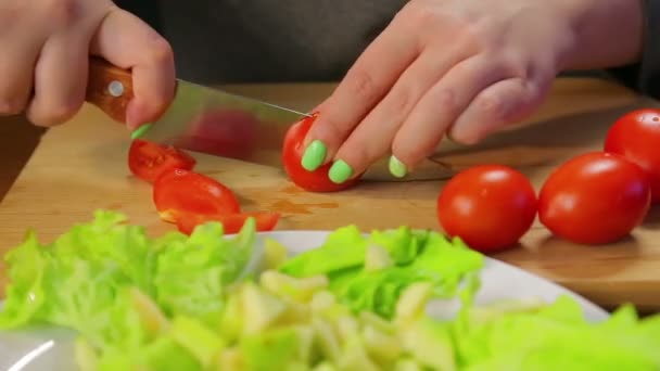 Mujer corta con un cuchillo un tomate cereza sobre una tabla de madera — Vídeos de Stock