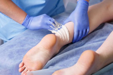 Eller kozmetik smear şeker yapıştırın yanında genç bir kadın için sol ayak topuk doktor
