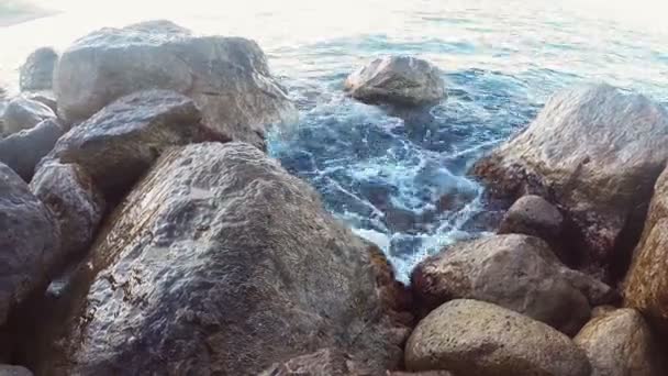 Steniga stranden och havet vatten stänk mellan stenarna — Stockvideo