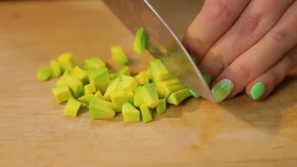 Fette di mano femminili sbucciate l'avocado in pezzi per insalata . — Video Stock