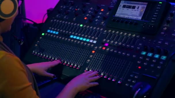 Mãos das mulheres trabalhando no console de mistura em iluminação colorida . — Vídeo de Stock