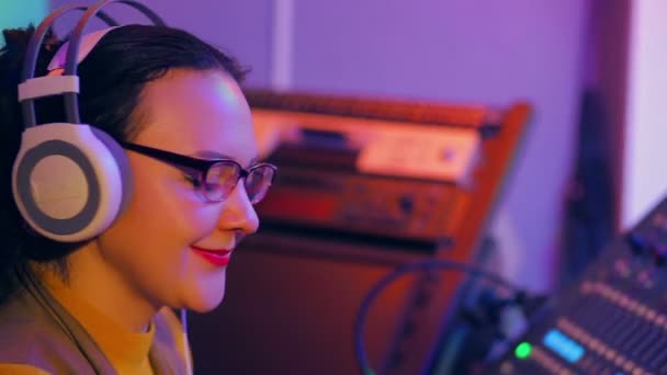 Le visage d'une DJ féminine dans les écoliers et les lunettes pendant le travail — Video