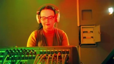 Kadın Dj kulaklık ve gözlük telsiz odasında, disko karıştırma konsolu tutar
