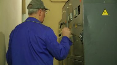 Bir elektrikçi mühendis elektrik paneli açar ve elektrikli ev aletleri okuma kaydeder
