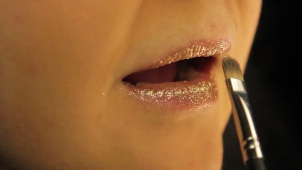 Una mano femminile condivide il suo trucco labbro con scintille d'oro — Video Stock