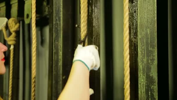 Руки женщины в перчатках снимают крепление с кабеля и опускают театральный занавес — стоковое видео