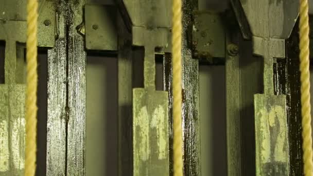 Male scene worker removes load from the lifting mechanism of a theater curtain — Stock Video