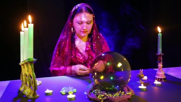 Zigeunerin in rotem Kleid und Schal legt die Karten im Spiegelbild der Kerzen aus — Stockvideo