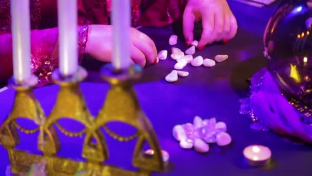 Mãos cigana que coloca sobre a mesa seixos brancos — Vídeo de Stock