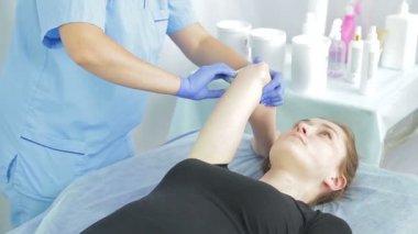 Güzellik kadının elleri genç bir kızın ellerin dirseklerinin shugaring yapmak.