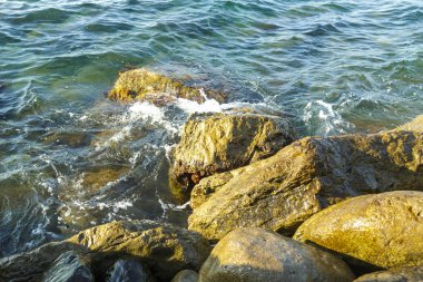 Deniz deniz köpüğü kayalık sahil yakınındaki kayalarda enkazı.