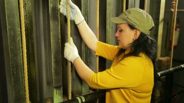 Las manos de la mujer el trabajador del escenario en guantes baja la cortina del teatro y sujeta el cable — Vídeo de stock