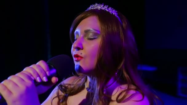 Sahnede genç esmer şarkıcı mikrophone tutarak söylüyor — Stok video