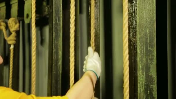 Händerna på en kvinna arbetar scen i handskar sänka teatern gardin med en kabel — Stockvideo