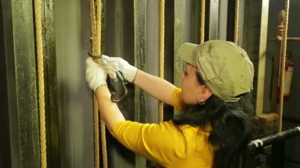 De handen van de vrouw de stadium arbeider in handschoenen maakt de kabel van het theater gordijn vast — Stockvideo