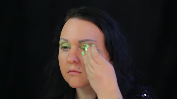 Brunette femme fait maquillage des yeux avec des ombres vertes . — Video