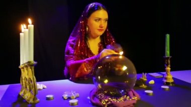 Bir eşarp içinde kırmızı bir elbise çingene eski bir mum çubuğu mum yanar. Ortalama plan