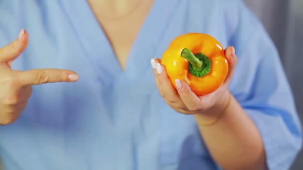 Yellow pepper in female hands. A hand is pointing at him. — Stock Video