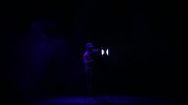 Bir kadın aydınlatıcı duman bir puf salonda bir profil spot ışık bir kiriş yönlendirir