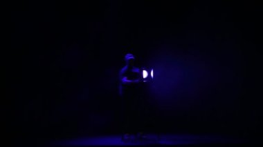 Bir adam aydınlatıcı duman bir puf içinde salona bir profil spot ışık bir Demet yönlendirir