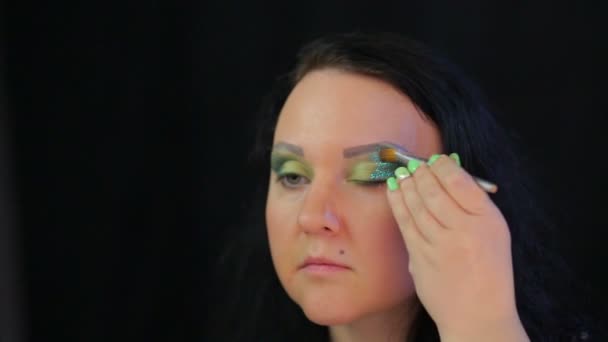 Brunetka kobieta stosuje soczyste zielone błyszczy na powieki. — Wideo stockowe