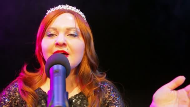 Νεαρή κοκκινομάλλα ηθοποιός τραγουδάει στη σκηνή στο μικρόφωνο μέσα σε καπνό — Αρχείο Βίντεο