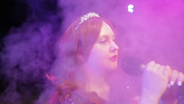 Jeune chanteuse rousse chantant sur scène au microphone dans une bouffée de fumée — Video